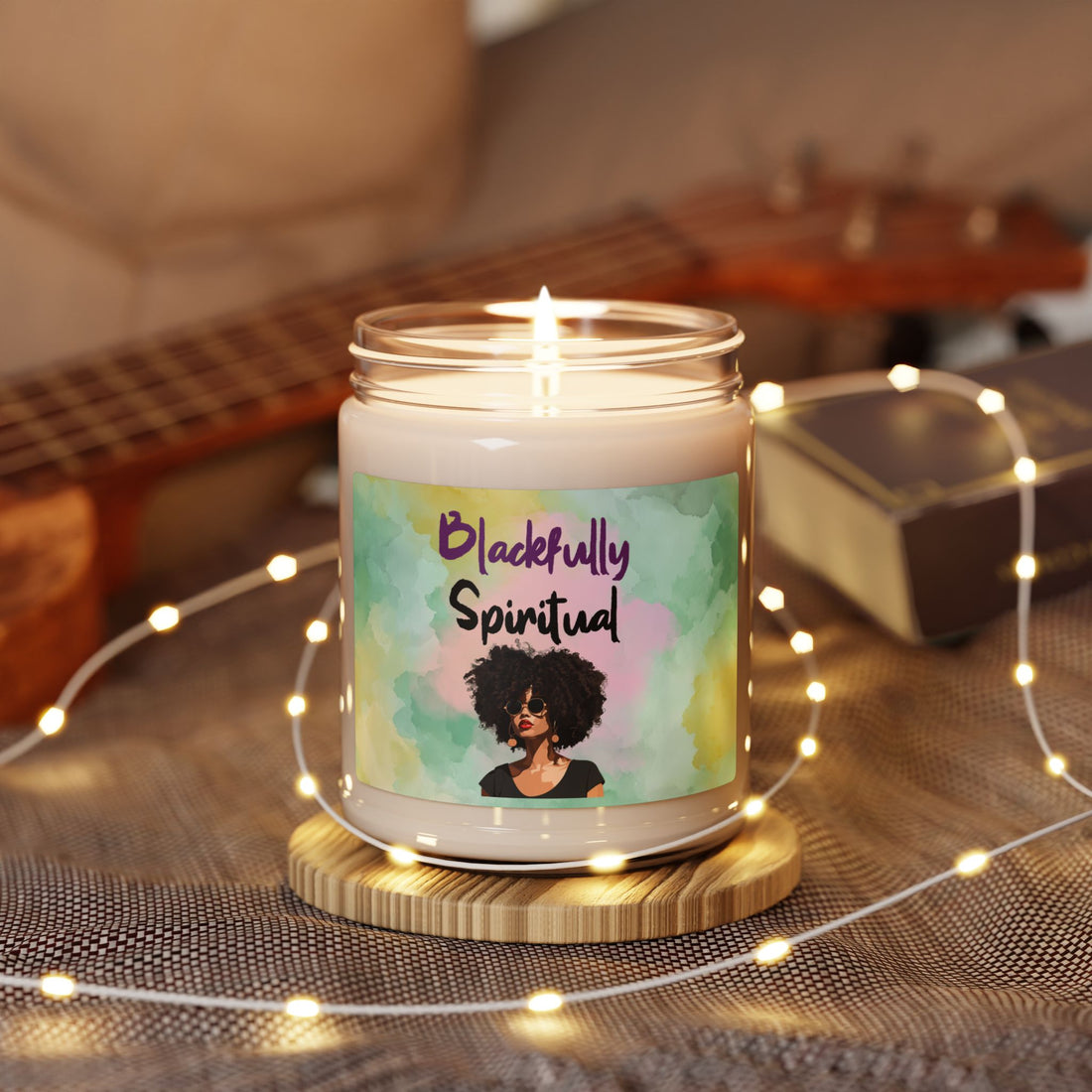 Candle in a jar with a label featuring an illustration of a woman with an afro, surrounded by string lights on a wooden surface.